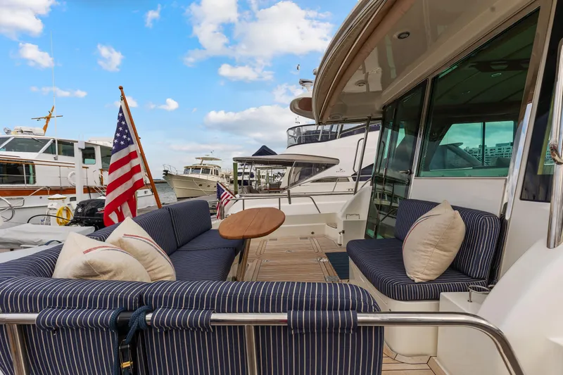 Second Rodeo Yacht Photos Pics 2018 Sabre 48 Salon Express yacht with striped seating and American flag at marina.