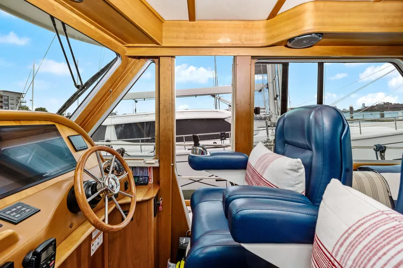 Second Rodeo Yacht Photos Pics Interior of 2018 Sabre 48 Salon Express yacht with blue leather seating and wooden helm.