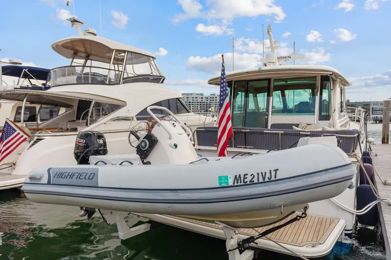 Second Rodeo Yacht Photos Pics 2018 Sabre 48 Salon Express yacht docked with inflatable boat, American flag displayed.