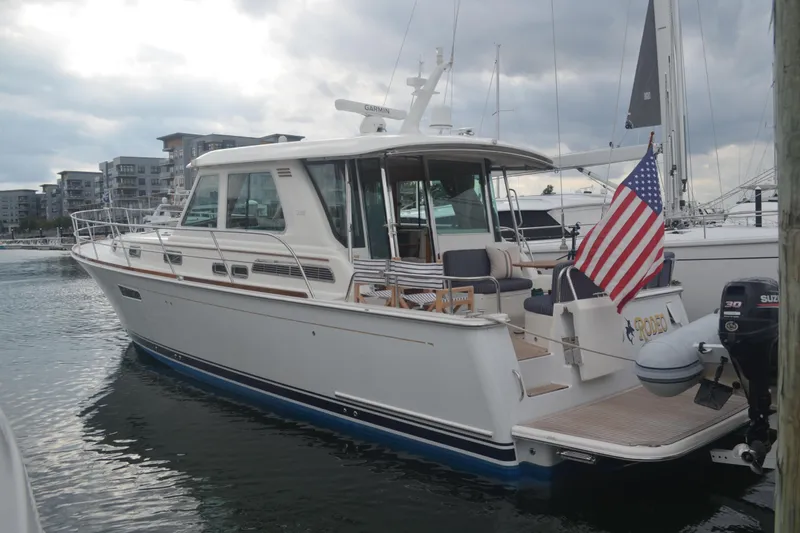 Second Rodeo Yacht Photos Pics 2018 Sabre 48 Salon Express yacht docked, featuring American flag and modern marina backdrop.