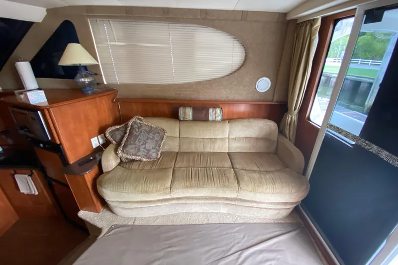 Carousel Yacht Photos Pics Interior of 2007 Silverton 36 Convertible yacht with beige sofa and wooden cabinetry.