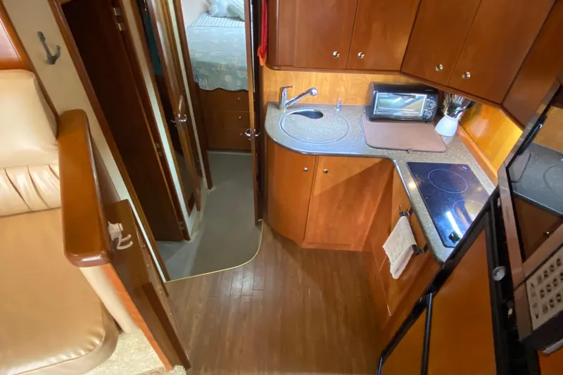 Carousel Yacht Photos Pics Interior of 2007 Silverton 36 Convertible yacht with compact kitchen and cozy cabin.