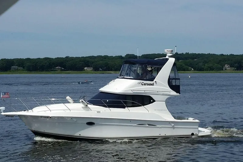 Carousel Yacht Photos Pics 2007 Silverton 36 Convertible yacht cruising on a serene lake with lush green shoreline.