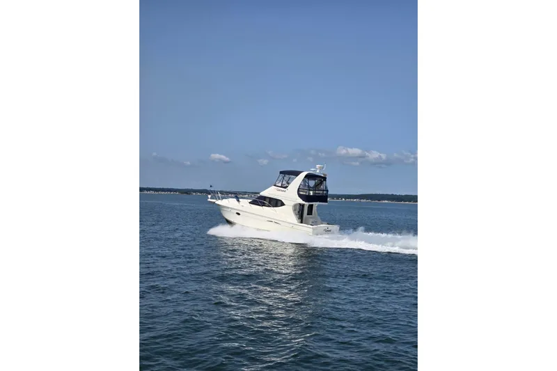 Carousel Yacht Photos Pics 2007 Silverton 36 Convertible yacht cruising on open water under clear blue sky.