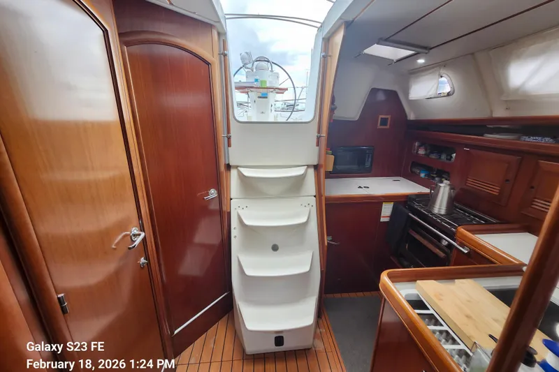 Little Su Yacht Photos Pics Interior of 2005 Beneteau Oceanis Clipper 393 sailboat, featuring kitchen and wooden cabinetry.