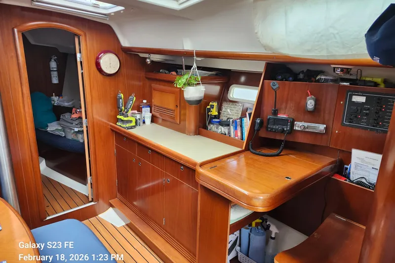 Little Su Yacht Photos Pics Interior of 2005 Beneteau Oceanis Clipper 393 sailboat with wooden cabinetry and navigation equipment.