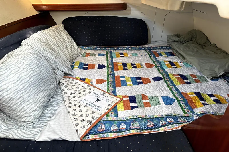Little Su Yacht Photos Pics Cozy cabin bed in 2005 Beneteau Oceanis Clipper 393 with colorful nautical quilt.