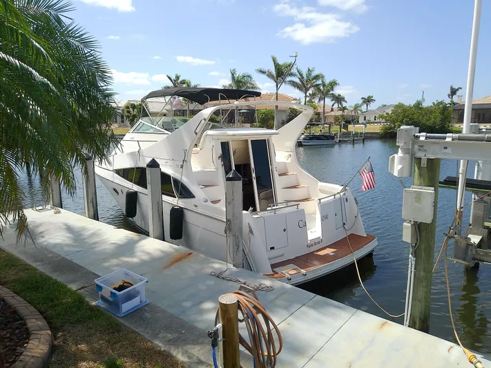 Cash Flow Yacht Photos Pics 2005 Carver 36 Mariner docked by palm trees, sunny day, American flag displayed.