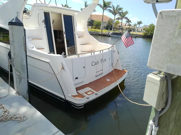 Cash Flow Yacht Photos Pics 2005 Carver 36 Mariner docked, displaying an American flag, with palm trees in the background.