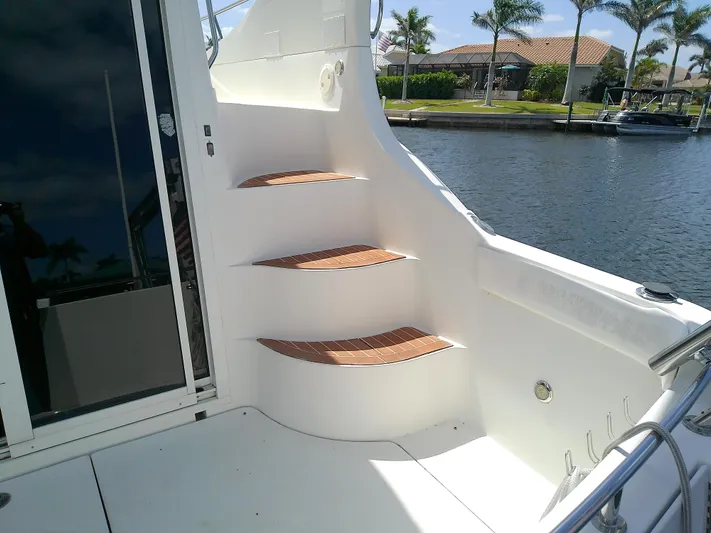 Cash Flow Yacht Photos Pics 2005 Carver 36 Mariner yacht with wooden steps, docked by a waterfront.