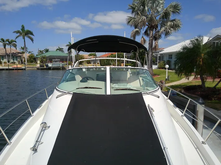 Cash Flow Yacht Photos Pics 2005 Carver 36 Mariner yacht docked by a canal with palm trees.