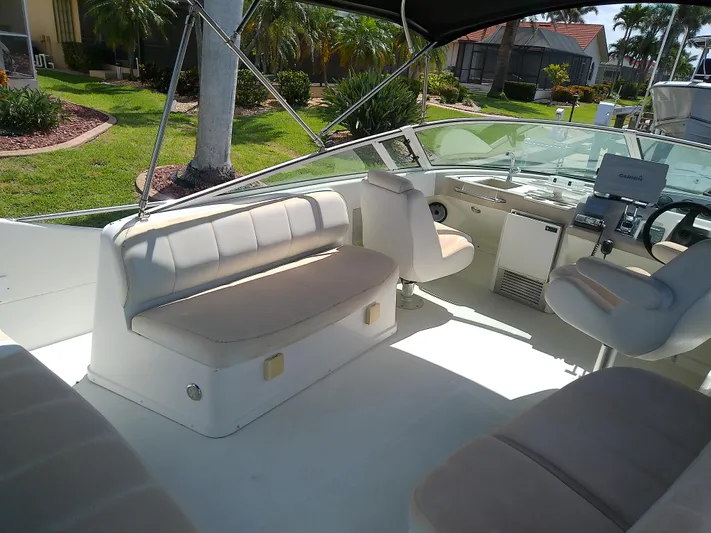 Cash Flow Yacht Photos Pics 2005 Carver 36 Mariner boat interior with seating and helm, docked near lush greenery.