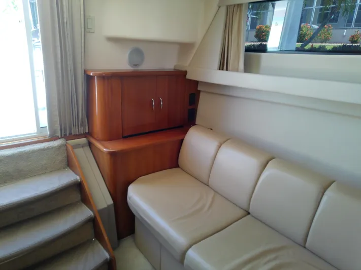 Cash Flow Yacht Photos Pics Interior of 2005 Carver 36 Mariner yacht with beige sofa and wooden cabinetry.