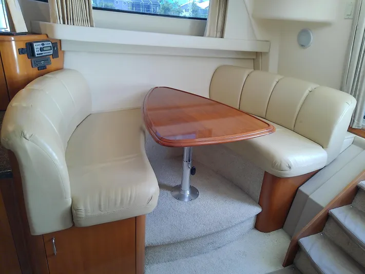 Cash Flow Yacht Photos Pics 2005 Carver 36 Mariner interior with beige leather seating and wooden table.