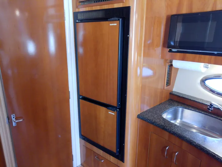 Cash Flow Yacht Photos Pics 2005 Carver 36 Mariner interior with wood-paneled fridge, microwave, and sink.