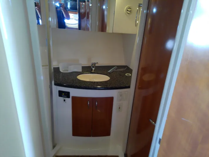 Cash Flow Yacht Photos Pics 2005 Carver 36 Mariner bathroom with sink, mirror, and wooden cabinetry.