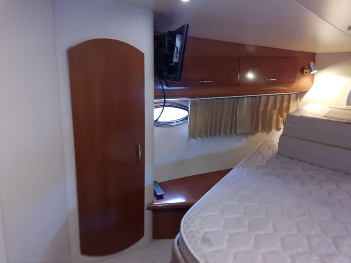 Cash Flow Yacht Photos Pics Interior cabin of 2005 Carver 36 Mariner with bed, TV, and wooden cabinetry.