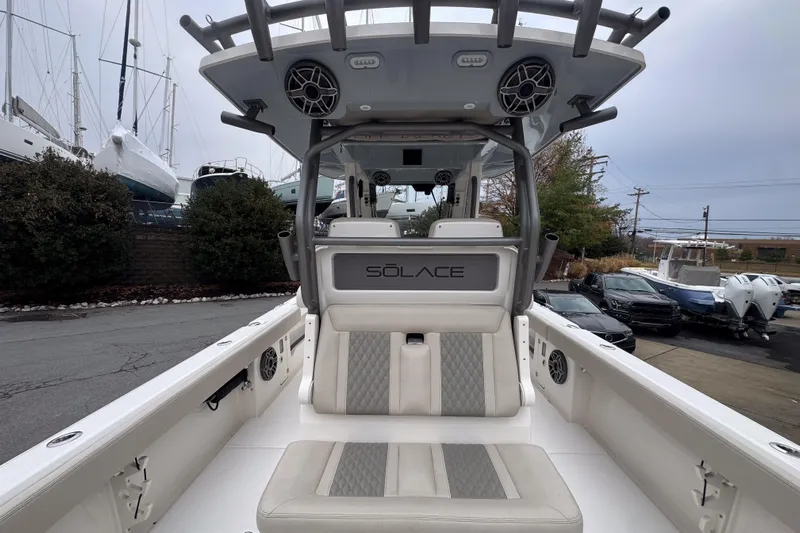  Yacht Photos Pics 2025 Solace 30 HCS boat interior with seating and speakers, docked near other boats.