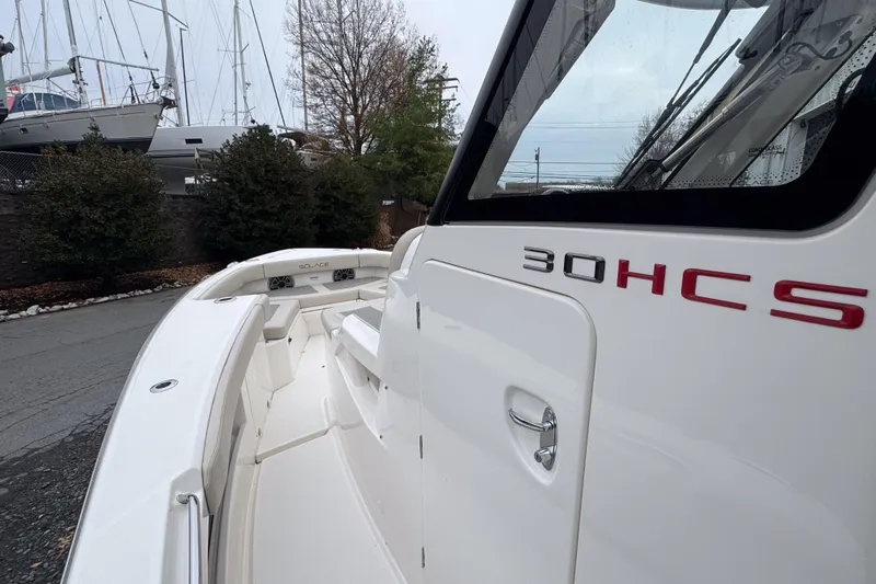  Yacht Photos Pics 2025 Solace 30 HCS boat, sleek white design, docked near other vessels.