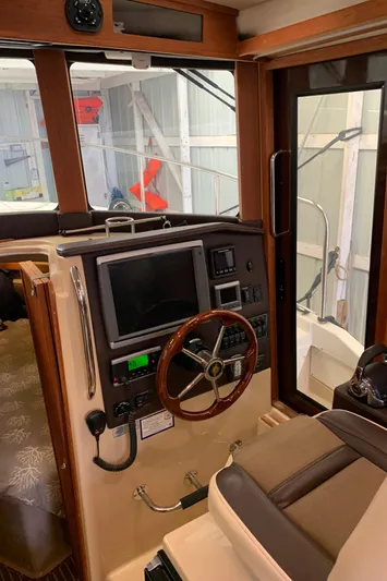  Yacht Photos Pics 2014 Ranger Tugs Trawler helm with navigation equipment and wooden steering wheel.