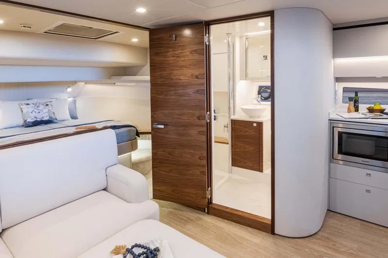  Yacht Photos Pics Manufacturer Provided Image: Luxurious interior of 2026 Riviera 4300 Sport Express yacht with bedroom, bathroom, and kitchenette.