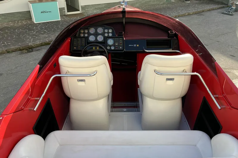  Yacht Photos Pics Interior of a 1994 Riva 32 Ferrari Special boat with white seats and dashboard controls.