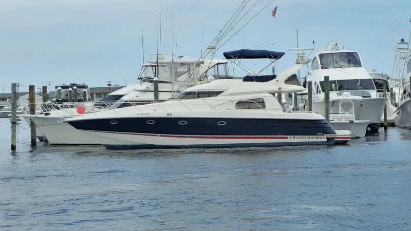  Yacht Photos Pics 1997 Sunseeker Manhattan 48 yacht docked at marina, surrounded by other boats.