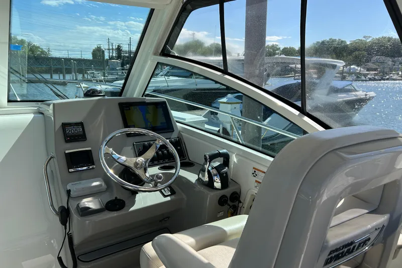  Yacht Photos Pics 2015 Boston Whaler 285 Conquest helm with steering wheel and navigation system.