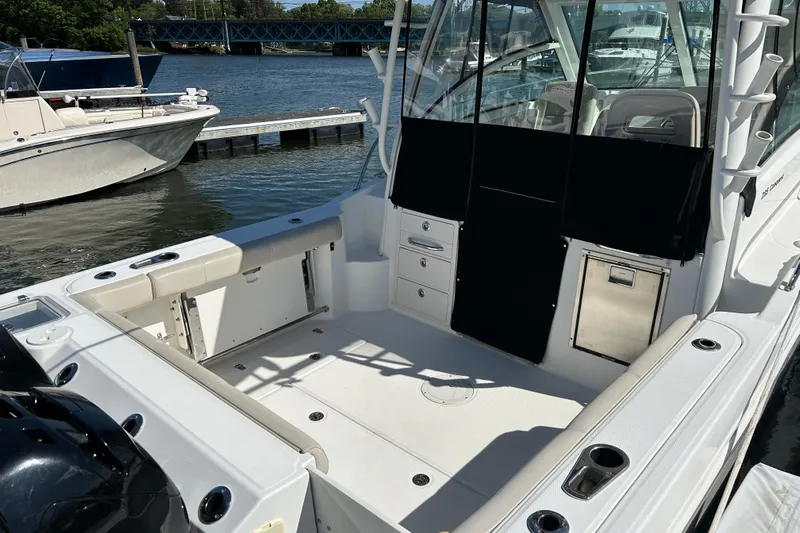  Yacht Photos Pics 2015 Boston Whaler 285 Conquest boat interior at dock, featuring seating and storage.