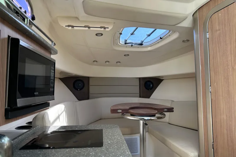  Yacht Photos Pics Interior of 2015 Boston Whaler 285 Conquest with seating, table, and kitchenette.