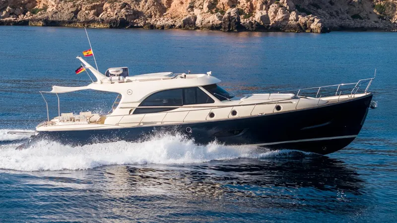 Tati Blue Yacht Photos Pics 2010 Mochi Craft 54 yacht cruising on blue water near rocky coastline.