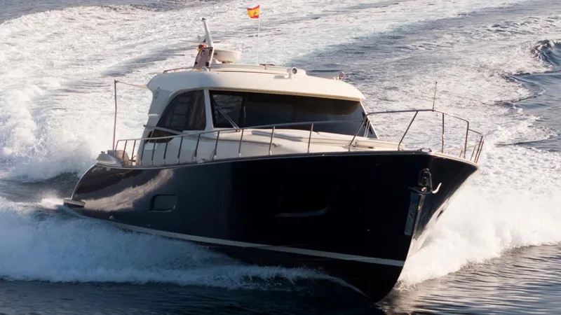 Tati Blue Yacht Photos Pics 2010 Mochi Craft 54 yacht cruising on open water, creating a dynamic wake.