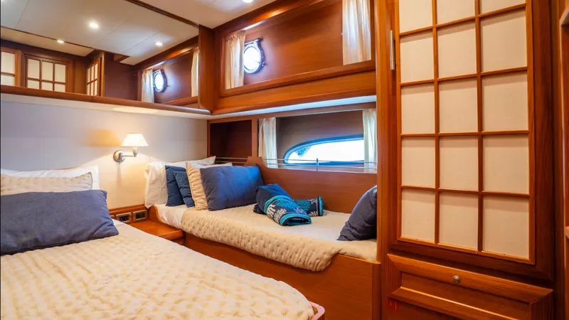Tati Blue Yacht Photos Pics Luxurious cabin interior of 2010 Mochi Craft 54 yacht with cozy beds and wooden decor.