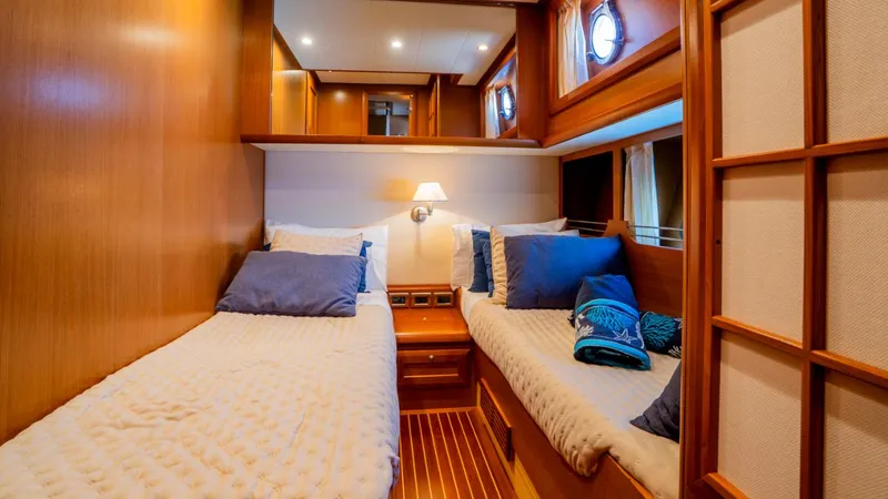 Tati Blue Yacht Photos Pics Luxurious twin cabin interior of 2010 Mochi Craft 54 yacht, featuring cozy bedding and elegant wood finishes.