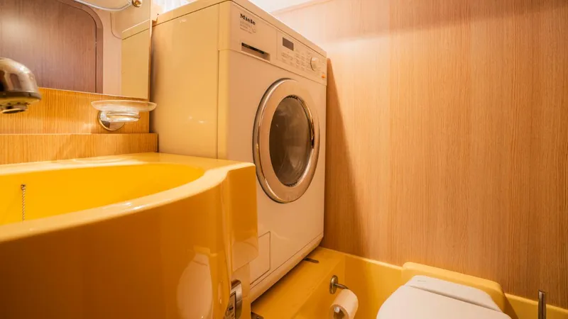 Tati Blue Yacht Photos Pics Laundry area in 2010 Mochi Craft 54 yacht with washer, yellow sink, and toilet.