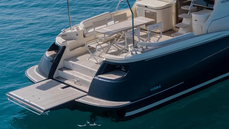 Tati Blue Yacht Photos Pics Luxury Mochi Craft 54 yacht, 2010 model, featuring elegant deck and seating area on calm water.