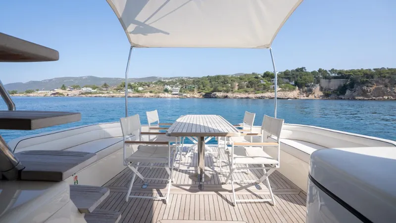 Tati Blue Yacht Photos Pics Luxury Mochi Craft 54 yacht deck with dining area, overlooking serene coastal waters, 2010 model.