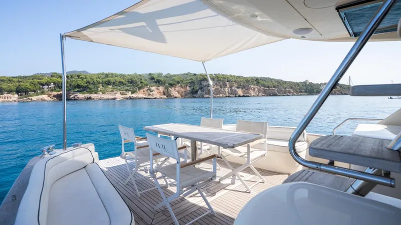 Tati Blue Yacht Photos Pics Luxury Mochi Craft 54 yacht deck with seating, overlooking serene blue waters and coastal scenery.