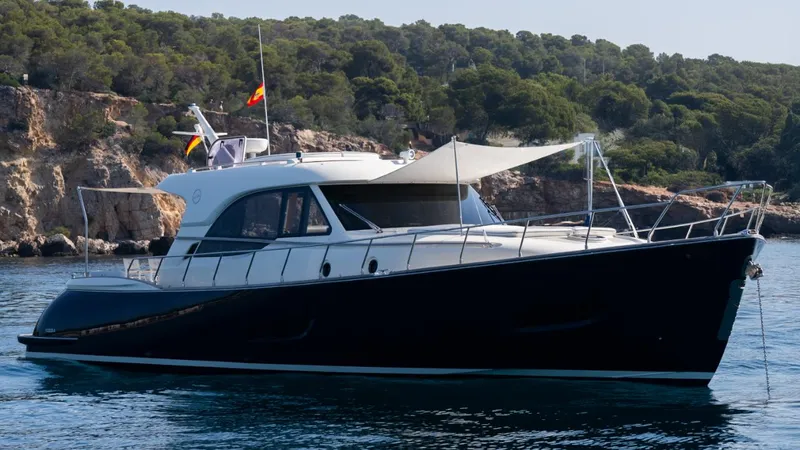 Tati Blue Yacht Photos Pics 2010 Mochi Craft 54 yacht on calm water near rocky coastline.
