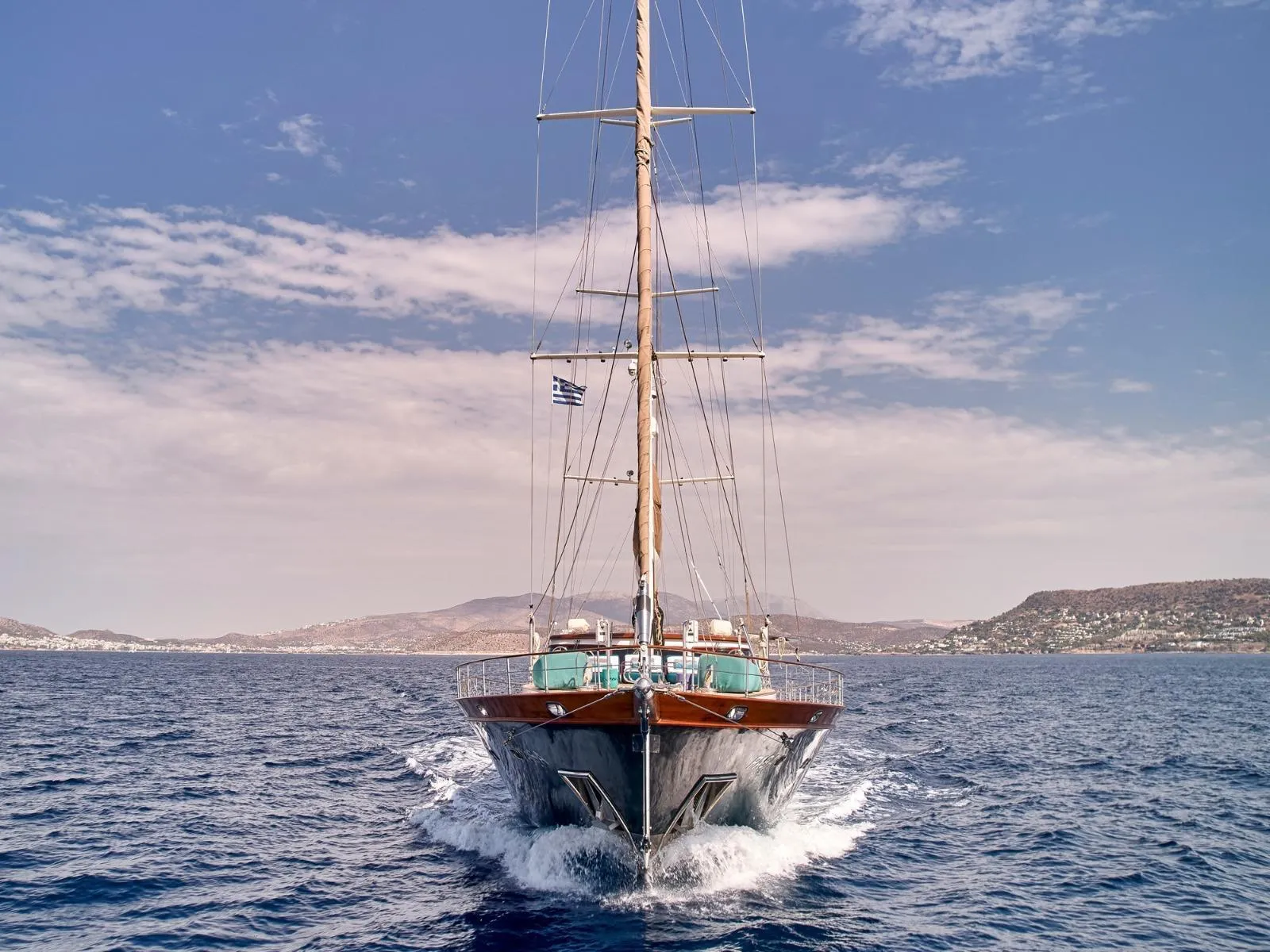 Elegant custom yacht sailing in open sea under clear blue sky, 2009 model.