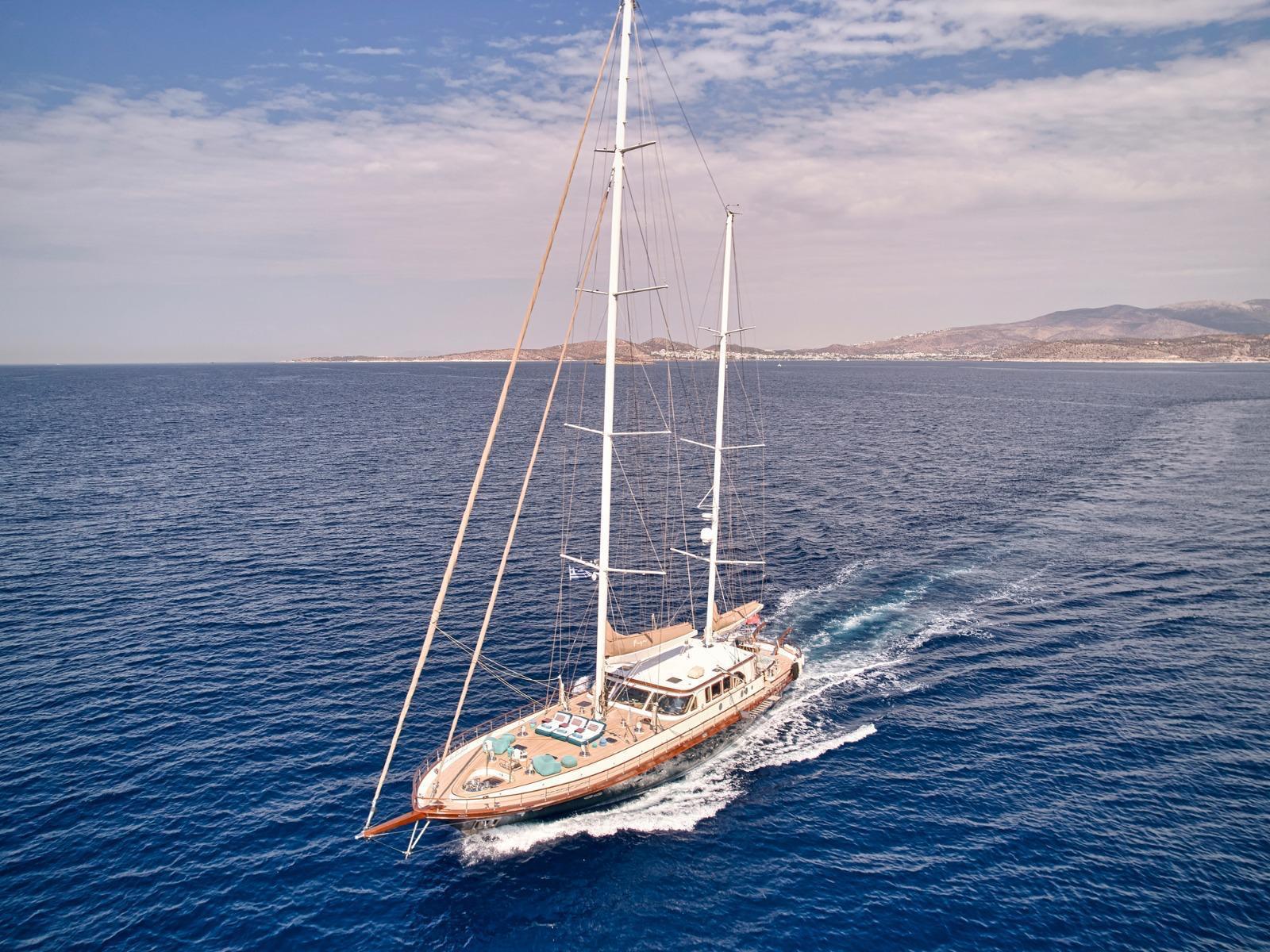 Luxurious custom yacht sailing on open sea, 2009 model, under clear blue skies.