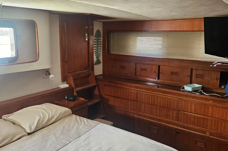  Yacht Photos Pics Interior of 1988 Cheoy Lee 51 Yacht, featuring wood cabinetry and a cozy sleeping area.