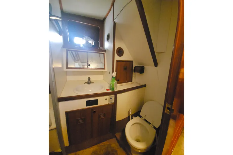  Yacht Photos Pics 1988 Cheoy Lee 51 Yacht bathroom with sink, mirror, and toilet in compact space.