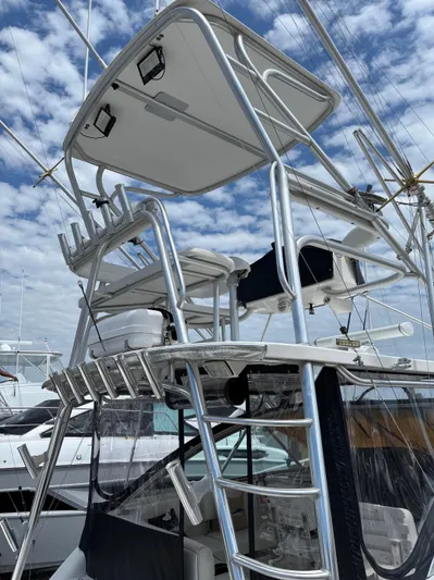 Yacht Photos Pics 2006 Rampage 38 Express boat with tower and ladder under a cloudy sky.