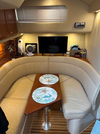  Yacht Photos Pics 2006 Rampage 38 Express cabin with beige seating, wooden table, and modern amenities.