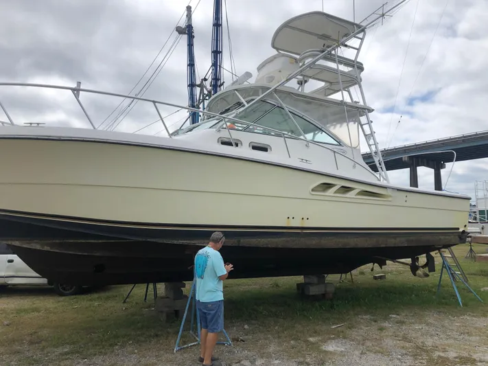  Yacht Photos Pics 2006 Rampage 38 Express boat on land with a person inspecting the hull.