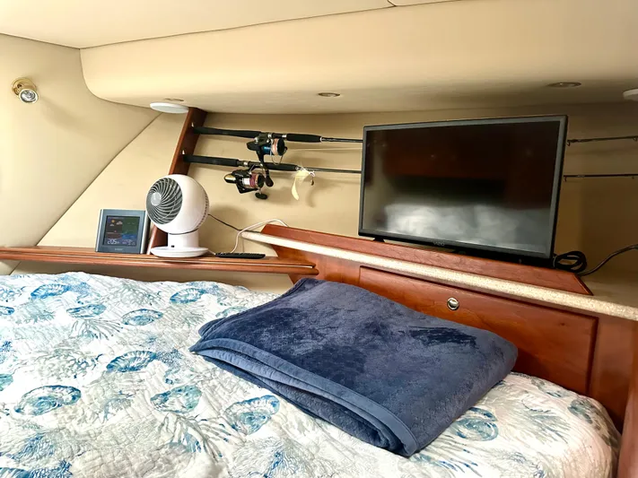  Yacht Photos Pics Cozy cabin interior of 2006 Rampage 38 Express with TV, fan, and fishing rods.