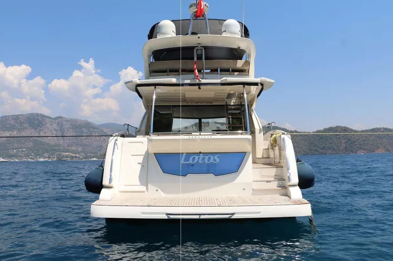  Yacht Photos Pics Luxury yacht Absolute 56 FLY 2015 on serene blue waters with scenic mountain backdrop.