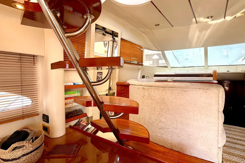  Yacht Photos Pics Luxurious interior of 2000 Fairline Squadron 55 yacht with wooden staircase and cozy seating.