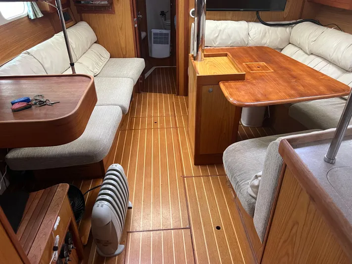 "helluva" Yacht Photos Pics Interior of a 2000 Hunter 410 sailboat with wooden flooring and cushioned seating.